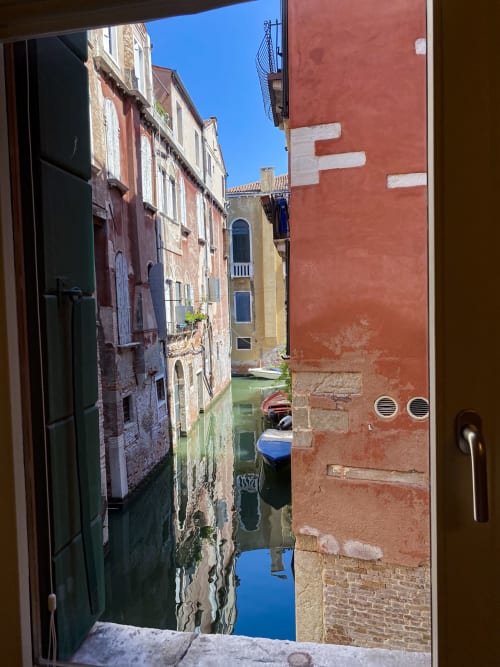 Venice canal view from Suite Superior window, colorful buildings and moored boats in Venetian waterway