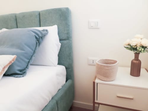 San Marco Luxury Suite Superior bedroom with green headboard, white bedding, and nightstand with flowers, Verona