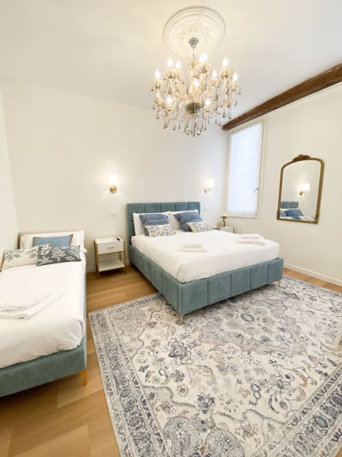 Elegant bedroom in San Marco Luxury Suite, Verona with twin beds, chandelier, and classic decor