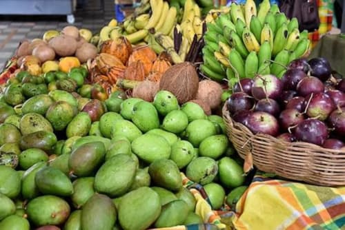 Étalage coloré du marché aux fruits tropicaux à Fort-de-France avec mangues, bananes et noix de coco