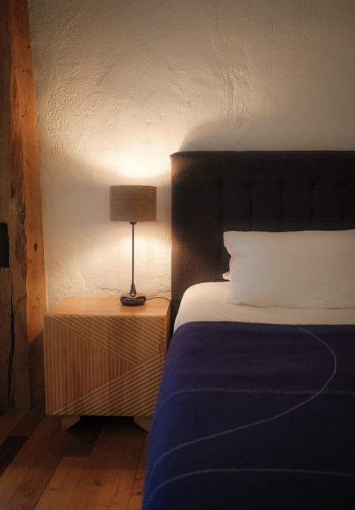 Bedroom at Moulin Renaudiots hotel in Autun with wooden nightstand, table lamp, and dark headboard