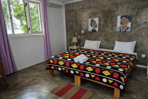 Quarto duplo no Hotel PZero em Albufeira com colcha geométrica colorida, decoração moderna e vista para o jardim pela janela