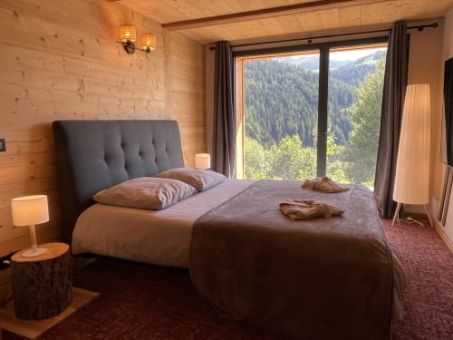 Chambre luxueuse du Chalet Monts d'Argent à La Plagne, avec vue montagne, boiseries et mobilier contemporain