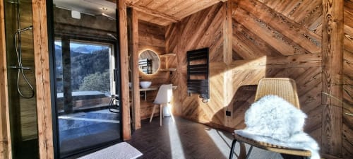 Intérieur de chalet alpin luxueux avec poutres en bois rustique, salle de bain moderne, sèche-serviettes chauffant et vues montagne aux Chalets