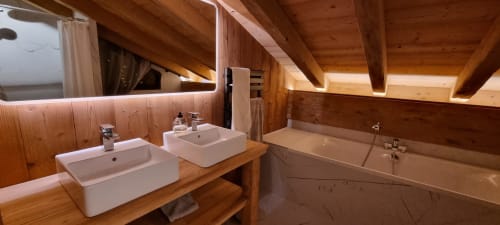 Salle de bain luxe en bois aux Chalets d'Aline, La Plagne : double vasque, baignoire et poutres apparentes
