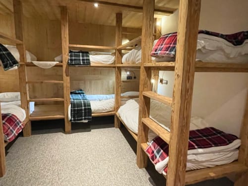 Lits superposés en bois avec literie à carreaux dans le dortoir du chalet Les Chalets d'Aline, La Plagne