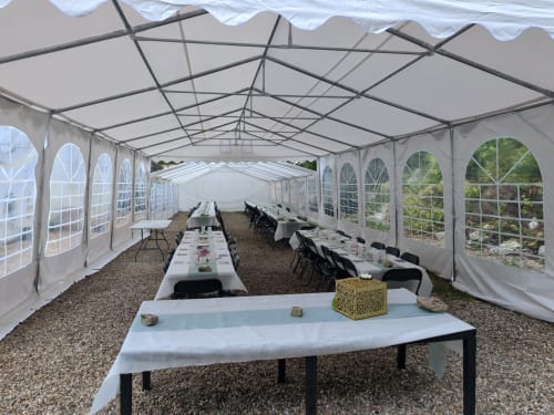 Grand chapiteau blanc aux Gîtes De Flaubert avec tables dressées pour un événement au Héron, France