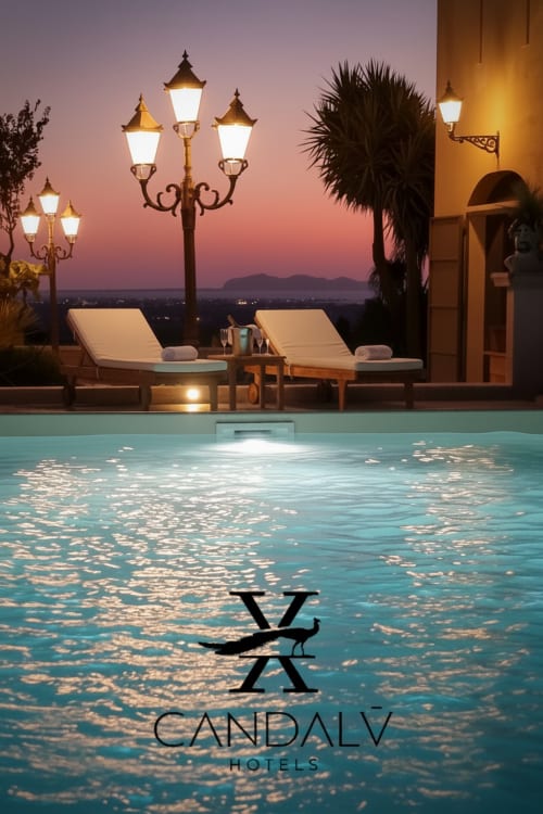 Lussuosa piscina al tramonto con lettini, lampade ornamentali e vista sulle montagne presso Candalú Hotels in Sicilia