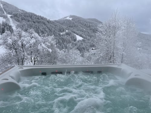 Bain à remous fumant avec vue sur les montagnes enneigées aux Chalets d'Aline, La Plagne