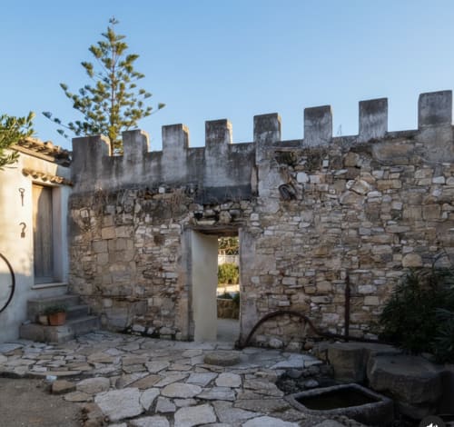 Cortile medievale in pietra con merlature al Candalú Hotel, Valderice Sicilia