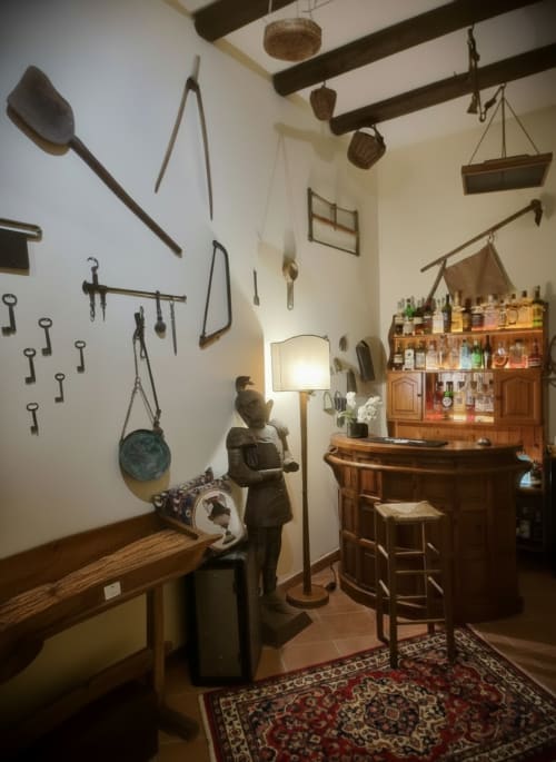 Suite rustica italiana con attrezzi da cucina vintage, mobili in legno e arredamento tradizionale all'Hotel Candalú di Valderice