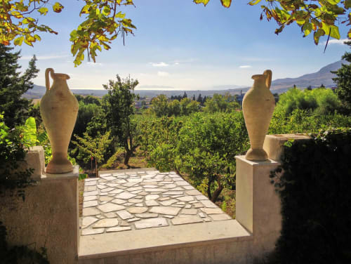 Sentiero in pietra con vasi in terracotta affacciati sui giardini di Valderice e le montagne lontane presso la Villa Giardinata di Candalú