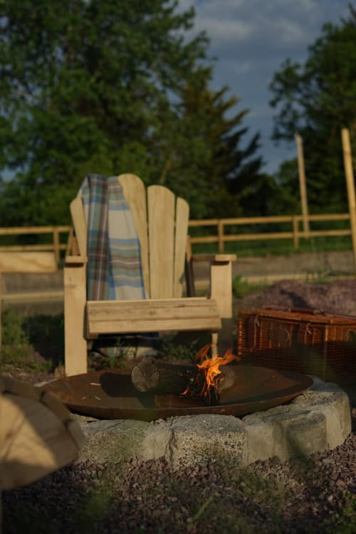Chaise Adirondack en bois avec plaid près du foyer de LA ROQUERIE Farmhouse, gîte rural de Bonneville-la-Louvet