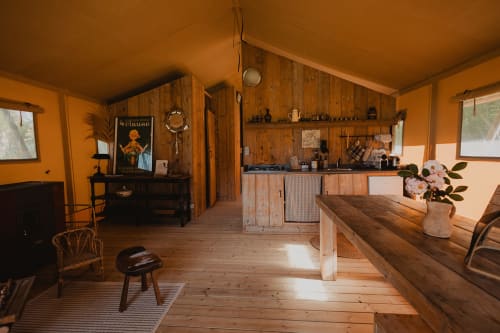 Intérieur de tente safari aux gîtes de Cormenin avec cuisine en bois, table à manger et vue sur le jardin