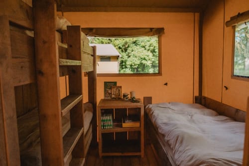 Chambre safari aux gîtes de Cormenin avec lits superposés, mobilier en bois et vue sur le jardin
