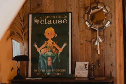 Affiche vintage 'Graines d'élite Clause' exposée sur mur en bois dans la chambre safari des gîtes de Cormenin avec jardin