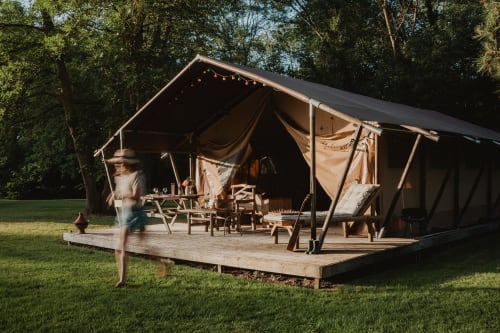 Tente safari aux gîtes de Cormenin avec terrasse en bois, espace de repas extérieur et vue sur le jardin à Saint-Hilaire-sur-Puiseaux