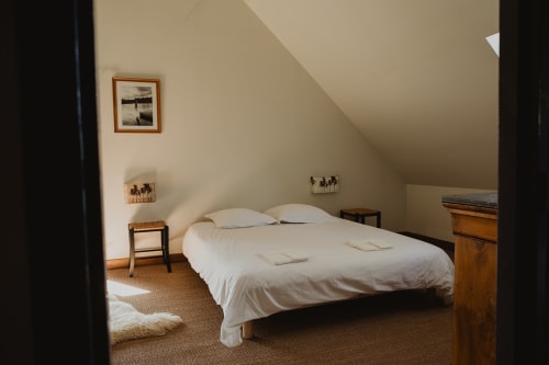 Chambre lumineuse à la villa La Muzardière à Saint-Hilaire-sur-Puiseaux avec lit queen-size, mobilier bois et vue sur le lac