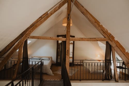Chambre mansardée rustique avec deux lits et poutres apparentes à la villa Les gîtes de Cormenin