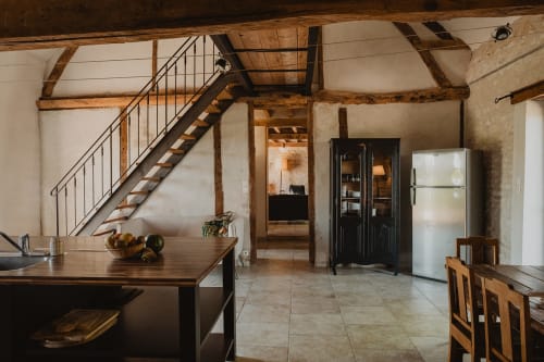 Cuisine de la villa La Muzardière avec poutres en bois, escalier, salle à manger et électroménager moderne aux Gîtes de Cormenin
