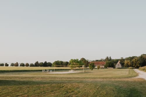Villa rurale avec filet de volleyball dominant des champs verdoyants et un horizon bordé d'arbres aux Gîtes de Cormenin, France