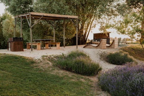 Pavillon de repas en plein air avec pergola en bois, tables de pique-nique et jardins de lavande à la villa Les gîtes de Cormenin