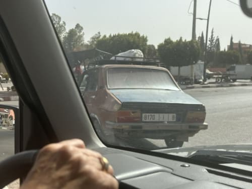 Vue du rétroviseur de véhicule montrant une voiture garée à El Ghazouane près de l'hôtel Eucalyptus Ethnic, Essaouira