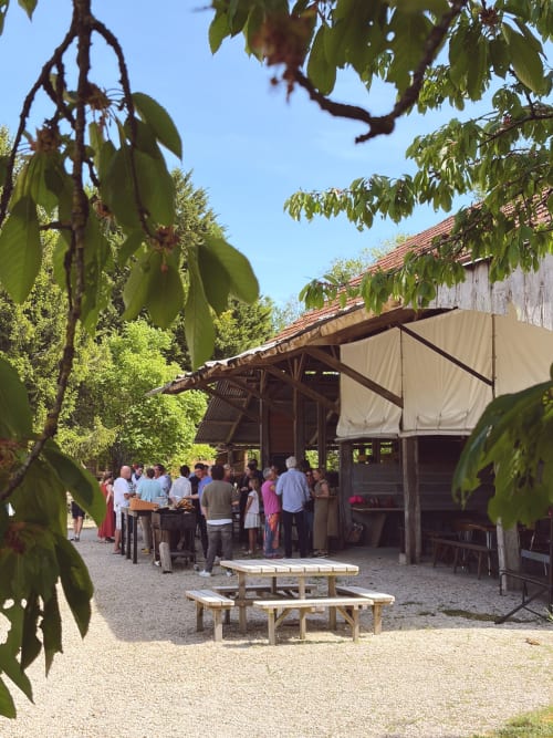 Réunion en plein air aux gîtes de Cormenin, Saint-Hilaire-sur-Puiseaux, avec des hôtes sous une structure de grange rustique