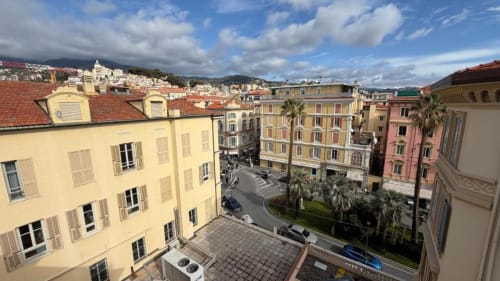 Terrazza con vista sul tetto di Sanremo: edifici colorati, palme e montagne dall'appartamento TuffonelBlu
