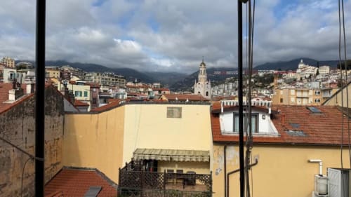 Vista dal terrazzo dell'appartamento TuffonelBlu a Sanremo: tetti in terracotta, montagne e campanile della chiesa