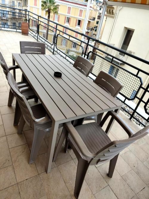 Set da pranzo moderno sulla terrazza dell'appartamento TuffonelBlu a Sanremo con vista sulla città mediterranea