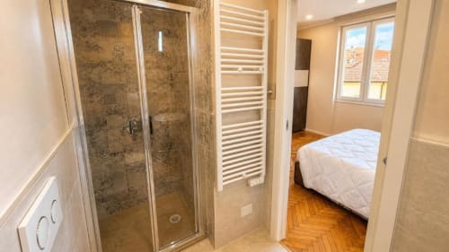 Bagno moderno con cabina doccia in vetro, scaldasalviette e finestre con vista sul mare a TuffonelBlu Sanremo