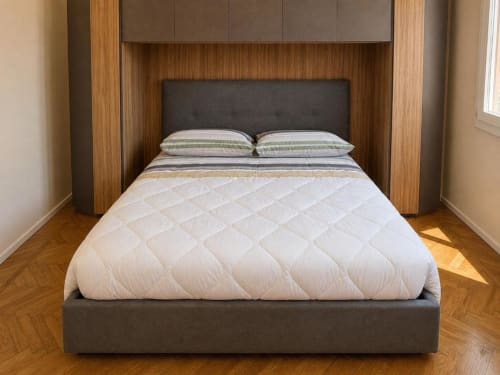 Camera da letto moderna nell'Attico Matteotti, TuffonelBlu hotel Sanremo, con letto imbottito grigio e trapunta bianca