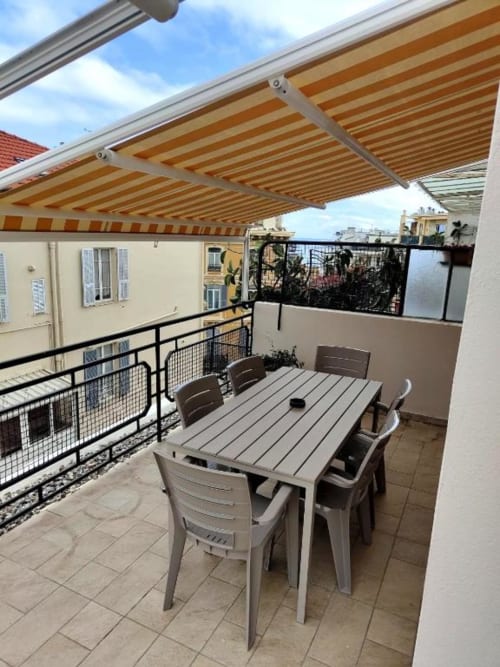 Terrazza sul tetto di TuffonelBlu a Sanremo con tenda a righe, tavolo da pranzo e vista sul mare