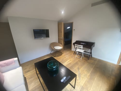 Séjour moderne de l'AJOUCADOU BnB Lourmarin avec téléviseur, salon confortable et parquet