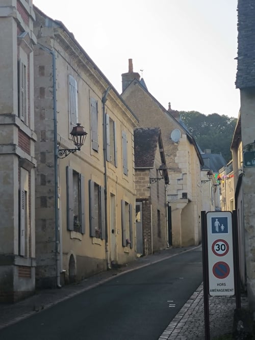 Charmante rue pavée de Courdemanche avec bâtiments historiques en pierre et panneau 30 km/h au Gîte de la vallée
