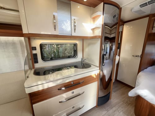 Interior moderno de autocaravana con cocina y dormitorio en B&B Wine And Cooking Penedès de Barcelona