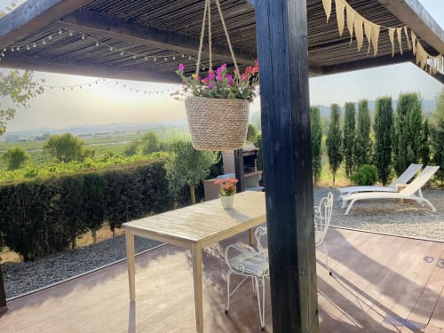 Pérgola con flores colgantes, mesa de madera y vistas a los viñedos en B&B Wine And Cooking Penedès