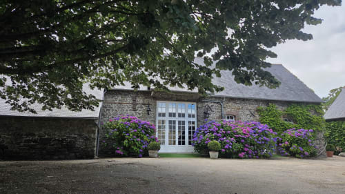 Stone manor entrance with purple hydrangeas, Manoir de la Bégaudière reception hall in Mont-Dol