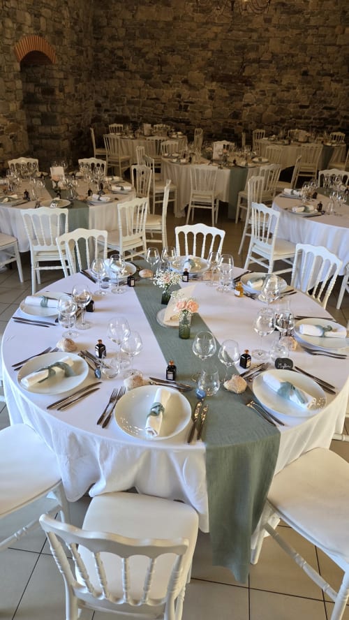 Elegantly set banquet tables in stone reception hall at Manoir de la Bégaudière, Mont-Dol