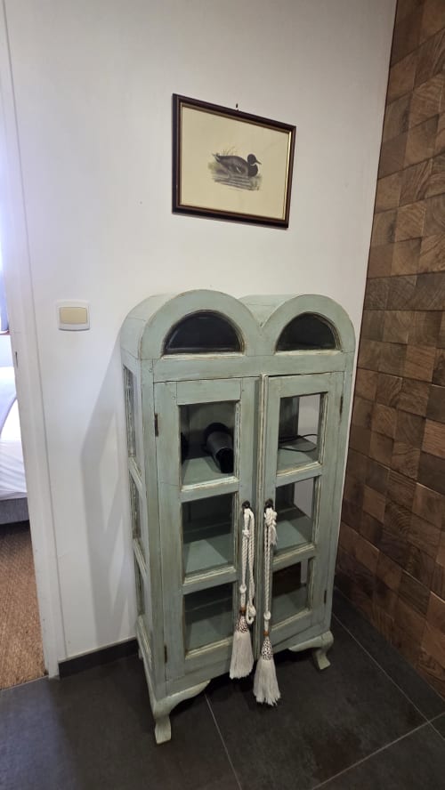 Vintage mint green display cabinet with glass doors in Le Jacques Cartier apartment at Manoir de la Bégaudière, Mont-Dol