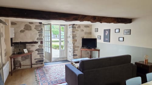 Le Jacques Cartier apartment at Manoir de la Bégaudière in Mont-Dol with stone walls, exposed beam, sofa, TV, and garden