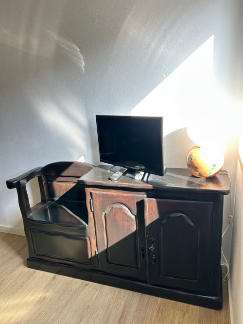 Escrivaninha de madeira escura com TV de tela plana e controle remoto na Casa das Rodas do Casas do Sinhel, Alvares, Portugal