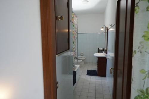 Bagno della camera Vista Mare presso Pupi Catania Etna Farm B&B ad Aci Castello con lavabo, toilette e zona doccia