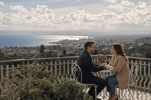 Coppia ammira la vista sul mare dalla terrazza del B&B Pupi Catania ad Aci Castello, Sicilia, con la costa del Mediterraneo