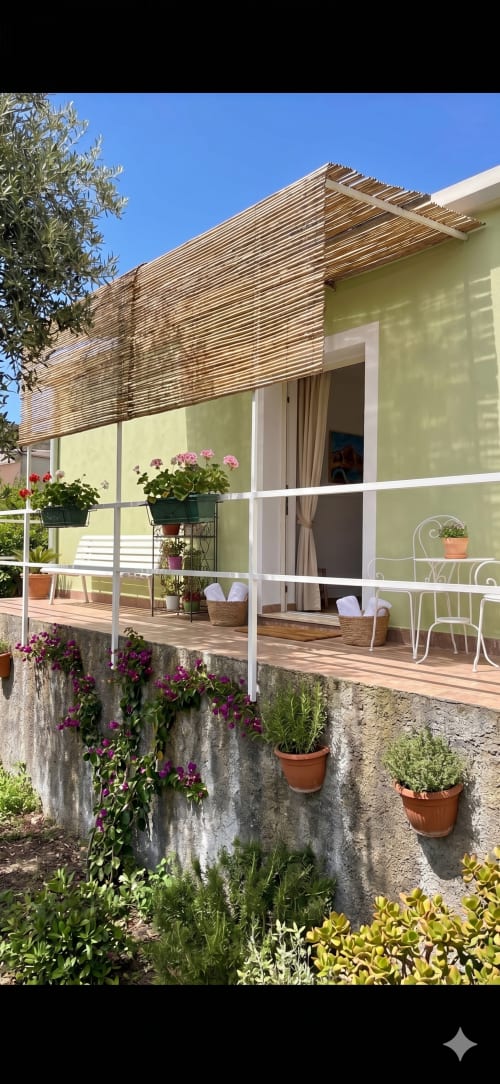 Cottage Sciara presso Pupi Catania Etna Farm B&B ad Aci Castello, Sicilia - facciata gialla con pergolato in legno, terrazza