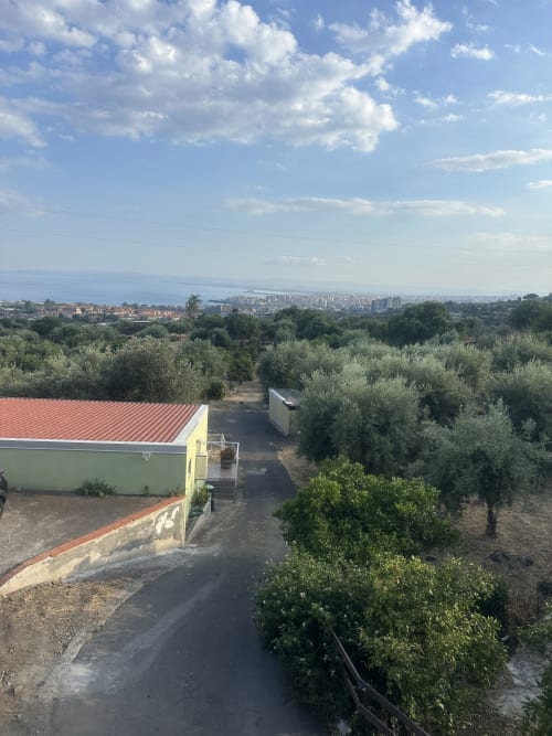 Terrazza della cottage di Pupi Catania Etna Farm B&B con uliveti e vista giardino verso Aci Castello e costa