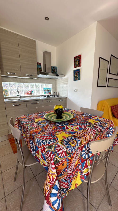 Luminosa zona cucina-pranzo della cottage Sciara Family a Pupi Catania con tovaglia a motivi colorati e arredi moderni