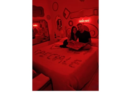 Coppia che si rilassa nella camera dal tema rosso della Pupi Catania Etna Farm B&B ad Aci Castello, Italia