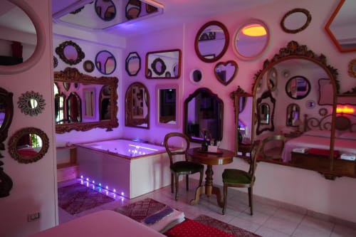 Stanza fiabesca in cottage rosa con specchi ornamentali, illuminazione viola e idromassaggio presso Pupi Catania B&B